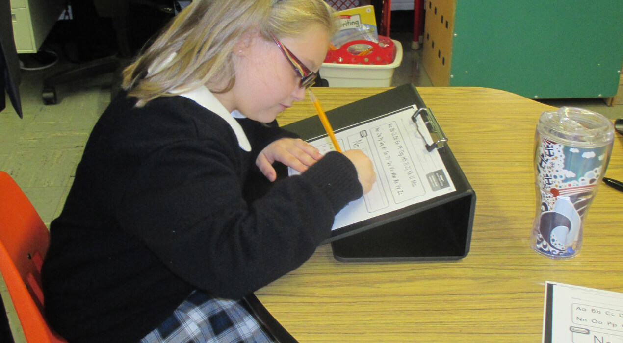 Child practicing her writing at a desk
